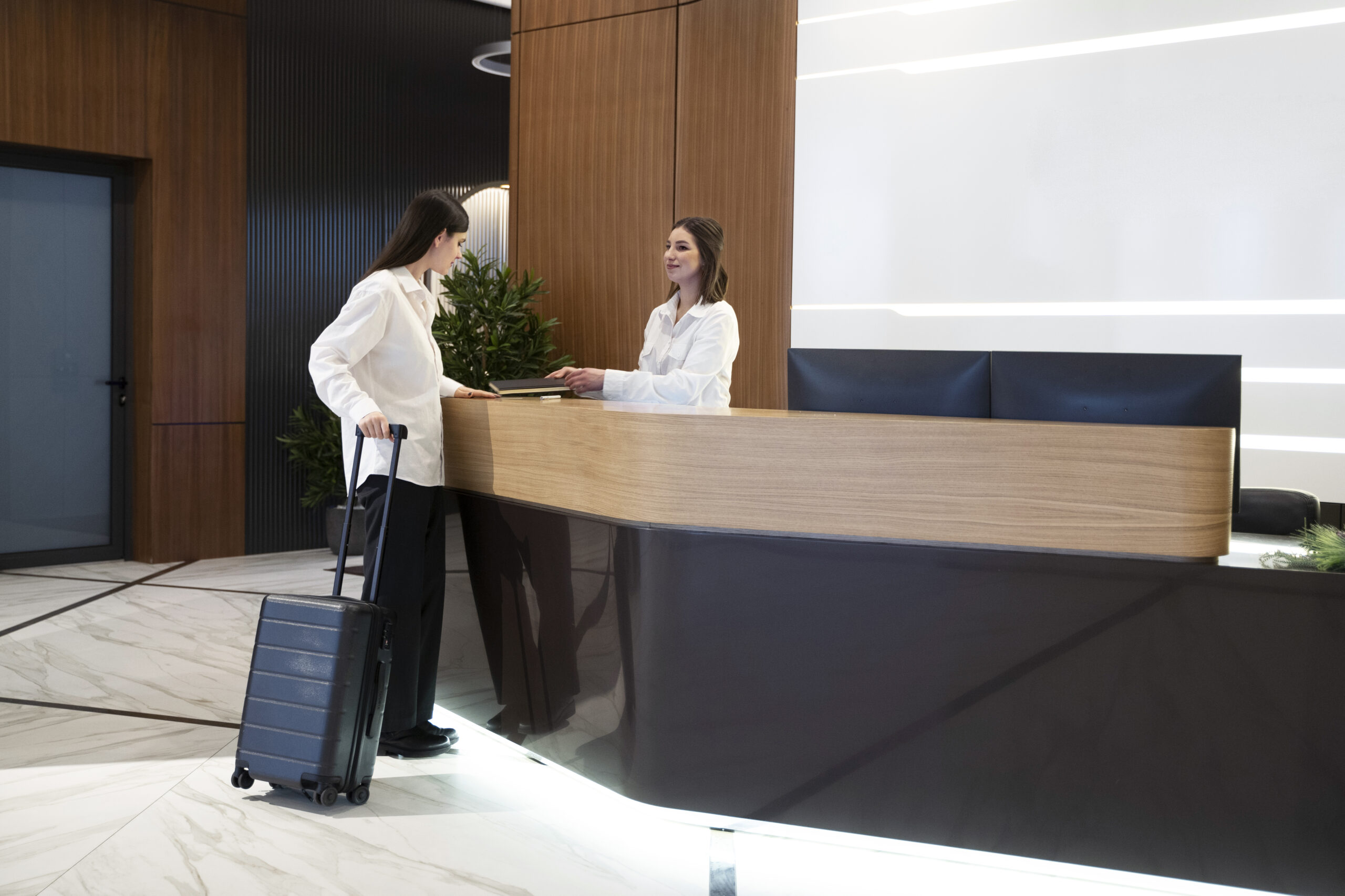 mujer hablando recepcionista hotel vestibulo scaled